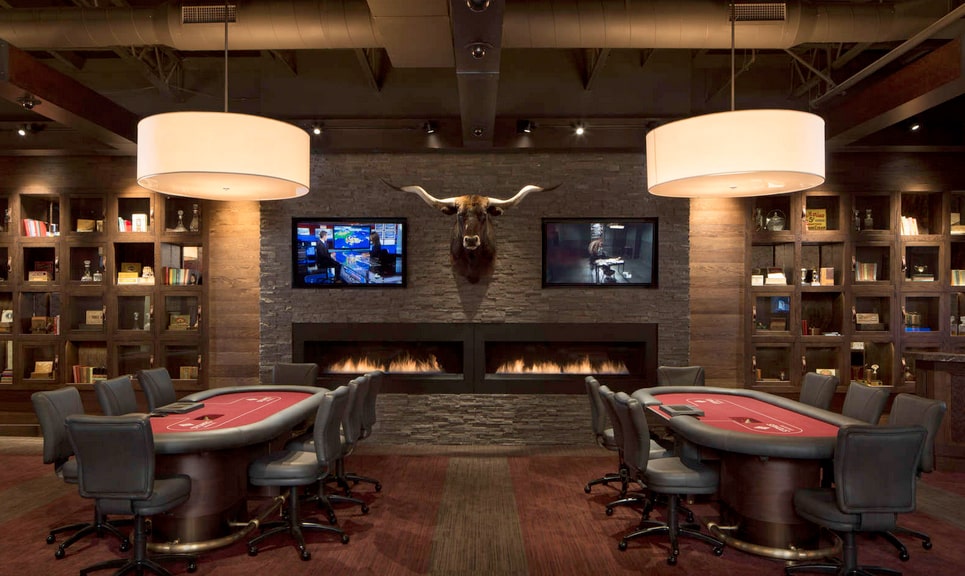 Norstone Charcoal Rock Panels on a large feature wall with two fireplaces, two tvs, and a stuffed longhorn cow head in an upscale card room man cave
